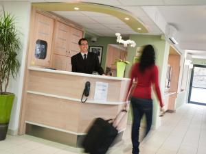 a man and a woman standing at a counter at ibis budget Augsburg City in Augsburg
