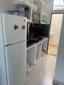 a kitchen with a white refrigerator and a sink at Casa Sol & Descanso Tocaima in Tocaima