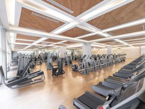 a gym with rows of treadmills and elliptical machines at Grand Mercure Ambassador Changwon in Changwon