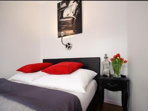 a bedroom with a bed with red pillows at Apartament 52 Old Town in Gdańsk