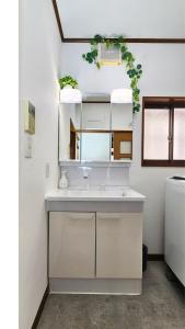 a white kitchen with a sink and a mirror at 足利すまいるハウス in Ashikaga +78 photos