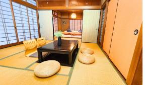 a living room with a table and two stools at 足利すまいるハウス in Ashikaga