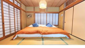 a bedroom with a large bed in a room with windows at 足利すまいるハウス in Ashikaga