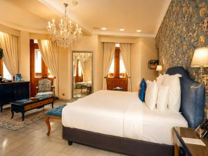a bedroom with a large white bed and a chandelier at La Concordia Boutique Hotel in Panama City