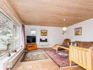 a living room with a couch and a tv at Lush holiday home in Thyholm in Thyholm