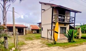 a house in the middle of a field at ICE POINT SURF HOUSES Praia do Rosa- Necessário Pré-pagamento Metade Valor Total in Praia do Rosa