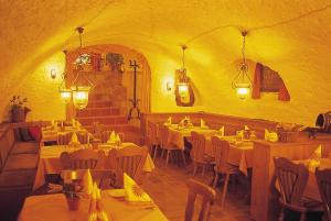 a restaurant with white tables and chairs and lights at Pfälzer Landhotel Heinrich in Bad Dürkheim