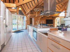 a kitchen with white appliances and wooden ceilings at Holiday home with pool in Ansager in Ansager