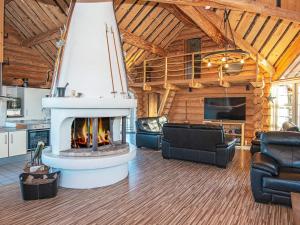 a living room with a fireplace in a log cabin at Holiday home with pool in Ansager in Ansager