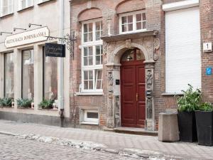 a brick building with a red door on a street at Apartament 52 Old Town in Gdańsk