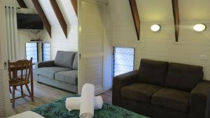 a living room with two couches and a table at Picnic Bay Chalet Unit 2 in Picnic Bay +10 photos