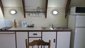 a kitchen with a sink and a white refrigerator at Picnic Bay Chalet Unit 2 in Picnic Bay