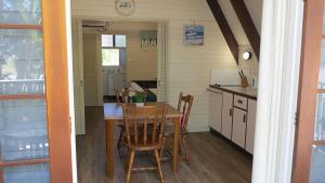 a kitchen and dining room with a table and chairs at Picnic Bay Chalet Unit 2 in Picnic Bay
