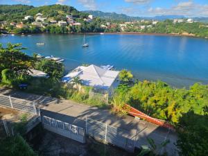 a view of a lake with a house and a boat at Beautiful sea view building in Le Robert