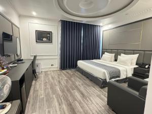 a hotel room with a bed and a couch at Sen plaza Hotel in Yên Thành
