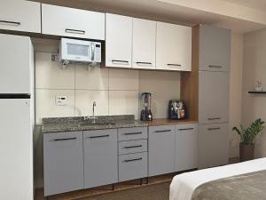 a white kitchen with a sink and a microwave at Franklin Studio Prime Rio Energy - Piscina, Sauna, Academia in Rio de Janeiro