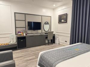 a bedroom with a bed and a desk with a television at Sen plaza Hotel in Yên Thành