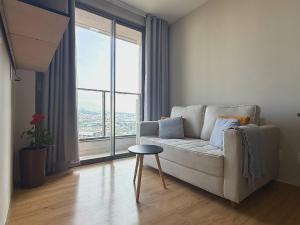 a living room with a couch and a large window at Franklin Studio Prime Rio Energy - Piscina, Sauna, Academia in Rio de Janeiro +16 photos