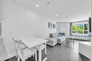 a living room with a white table and a couch at Central Alpine Condo in Whistler +22 photos