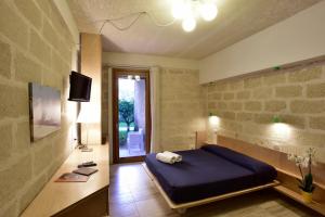 a bedroom with a bed and a television in it at Cave Bianche Hotel in Favignana