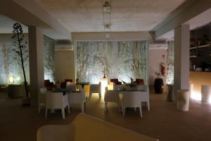 a restaurant with tables and chairs and a large wall at Cave Bianche Hotel in Favignana