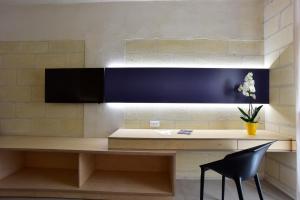 a desk in a room with a black chair at Cave Bianche Hotel in Favignana