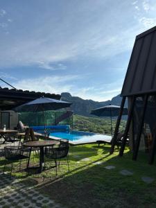a pool with tables and umbrellas next to at Macpalo in Amatlán