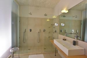 a bathroom with a shower and a sink and a tub at Cave Bianche Hotel in Favignana