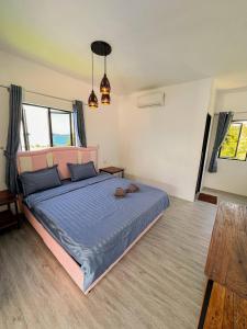 a bedroom with a large bed with a blue comforter at The Up Koh Rong in Kaôh Rŭng (3)