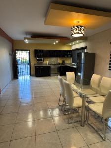a large kitchen with a table and white chairs at Beach house in San Miguel, Ensenada in Ensenada
