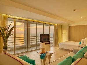 a hotel room with a bed and a view of the ocean at Pullman Pattaya Hotel G in North Pattaya