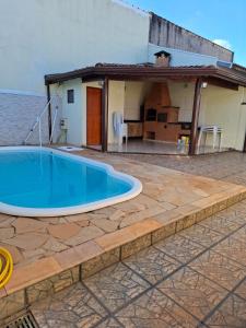 a swimming pool on a patio with a house at Casa c Piscina em Holambra in Holambra