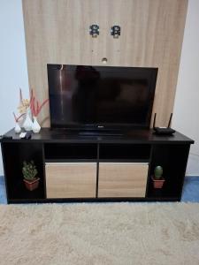 a black entertainment center with a flat screen tv at Casa c Piscina em Holambra in Holambra