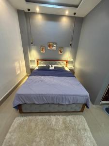 a bedroom with a bed with a purple comforter at Pearl Haven in Jorhat