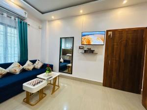 a living room with a blue couch and a table at Pearl Haven in Jorhat