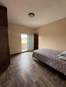 a bedroom with a bed and a wooden floor at CasaLyz in Rosarito Beach