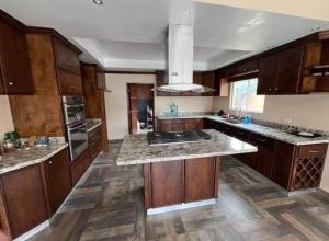 a large kitchen with wooden cabinets and granite counter tops at CasaLyz in Rosarito Beach