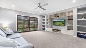 a living room with a couch and a tv at Alkira at The Vintage in Pokolbin +14 photos