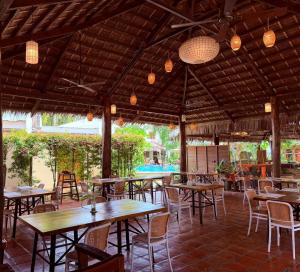 an outdoor restaurant with tables and chairs and lights at Acacia Tree Garden Hotel in Puerto Princesa City
