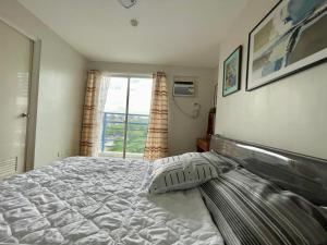 a bedroom with a large bed and a window at Nier Haven at The Loop North Tower in Pontud