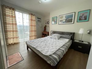 a bedroom with a bed and a large window at Nier Haven at The Loop North Tower in Pontud