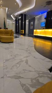 a large lobby with a yellow couch and a floor at Damac Al Jawharah Tower Versace Sea View شقة فرزاتشي بإطلالة بحرية برج داماك الجوهرة in Jeddah