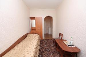 a bedroom with a bed and a table at Hotel Salut in Orsk
