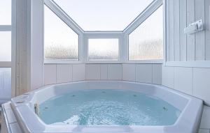 a large bath tub in a room with two windows at Strandpark 9 in Schönhagen