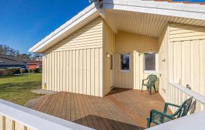 a building with a deck with two chairs on it at Strandpark 9 in Schönhagen +21 photos
