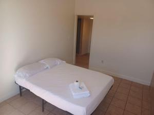 a small white bed with a box of tissues on it at Sunset Motel in Las Vegas