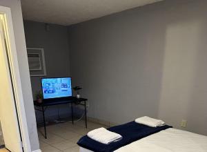 a bedroom with a bed and a flat screen tv at Sunset Motel in Las Vegas
