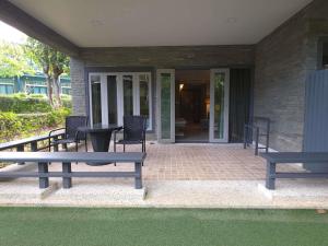 a patio with two benches and a table and chairs at Mercure Koh Chang Hideaway in Ko Chang +281 photos