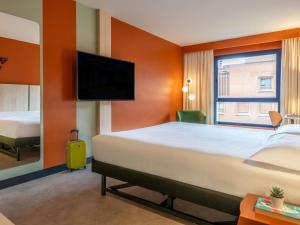 ein Hotelzimmer mit Bett und Flachbildfernseher in der Unterkunft Ibis Styles Zaragoza Centro in Saragossa