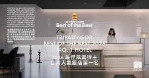 a woman standing on top of a wall with a sign at Kimpton Da An Taipei by IHG in Taipei